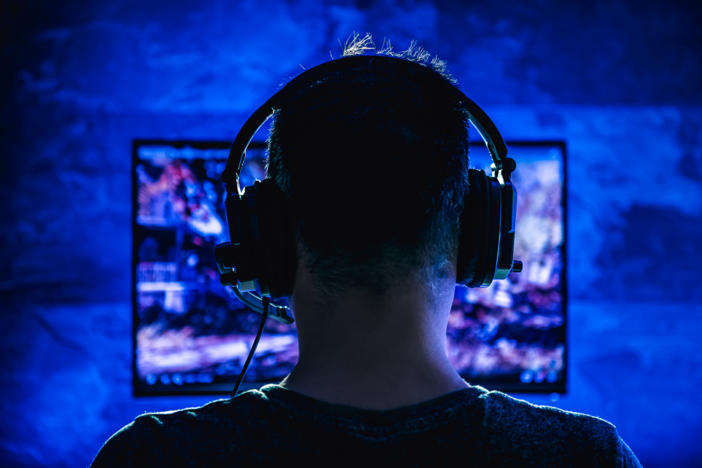 a man immersed in a video game while wearing a headset and surrounded by an all-blue environment
